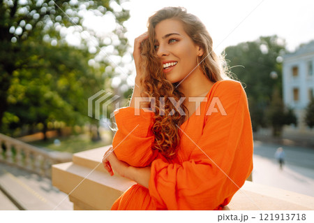 Female tourist in bright dress enjoys sights of the city on sunny day. Concept of lifestyle, fashion 121913718
