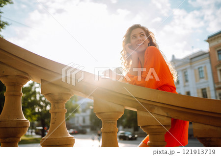 Female tourist in bright dress enjoys sights of the city on sunny day. Concept of lifestyle, fashion 121913719
