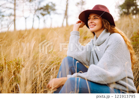 Stylish woman in hat enjoying autumn weather in the park. Fashion, style concept. 121913795