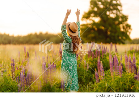 Beautiful woman in style dress on blooming fragrant lavender fields. Nature, vacation, lifestyle 121913916