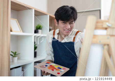 Creative young artist painting in modern studio indoor setting inspirational atmosphere close up perspective Creative young artist painting in modern studio indoor setting inspirational atmosphere close up perspective 121914449