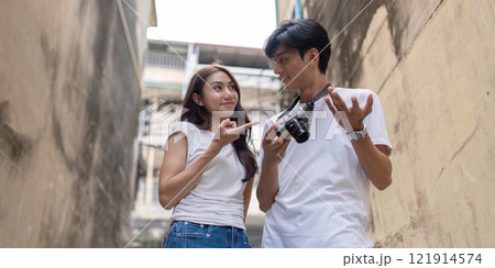 Adventurous travel couple capturing moments in urban alley candid vibrant atmosphere intimate perspective Adventurous travel couple capturing moments in urban alley candid vibrant atmosphere intimate perspective 121914574