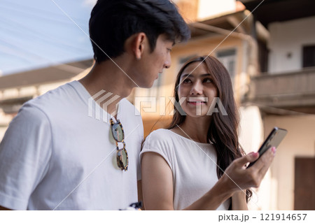 Couple traveling together in a vibrant city candid urban environment joyful moments 121914657