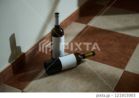 Two wine bottles on a tiled floor with blank labels Two wine bottles on a tiled floor with blank labels 121915003