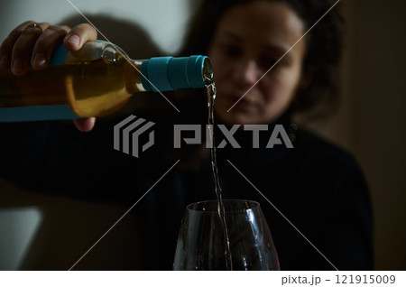 Closeup of wine being poured into a glass with a blurred background 121915009