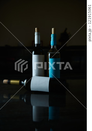 Elegant composition of wine bottles with blank labels on reflective surface 121915061