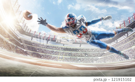 Football. Sportsman in action. Player catches the ball and flies in the air. Professional sports background for advertisement with lights, fans and flags Football. Sportsman in action. Player catches the ball and flies in the air. Professional sports background for advertisement with lights, fans and flags 121915102