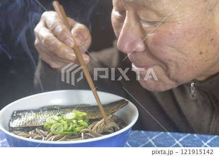 丼に湯気の立ち昇るニシン蕎麦を笑顔で食べる老人 121915142