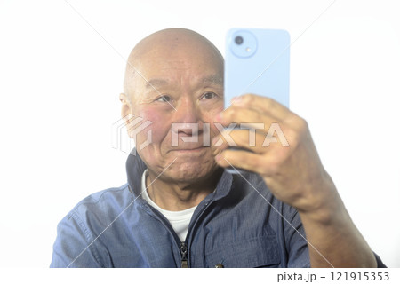 笑顔でスマートフォンを操作する老人 笑顔でスマートフォンを操作する老人 121915353