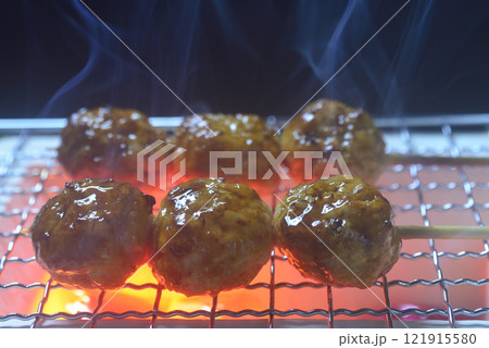 煙の立ち昇る七輪で鶏つくねを焼く 121915580