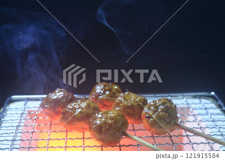 煙の立ち昇る七輪で鶏つくねを焼く 煙の立ち昇る七輪で鶏つくねを焼く 121915584