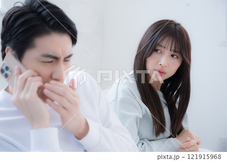 休日の朝に仕事の電話がかかってきて気まずい夫と妻 休日の朝に仕事の電話がかかってきて気まずい夫と妻 121915968