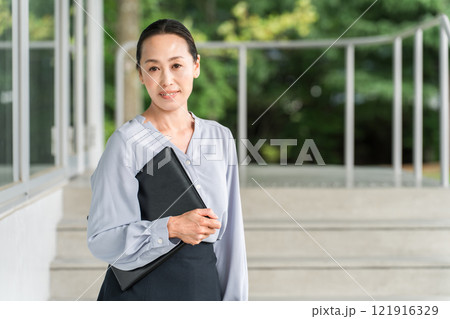 学校の廊下を移動する教員・教師の女性(高校・中学校) 学校の廊下を移動する教員・教師の女性(高校・中学校) 121916329