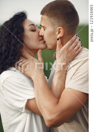 Couple in a field. Brunette in a white t-shirt. Pair walks. Couple in a field. Brunette in a white t-shirt. Pair walks. 121916865