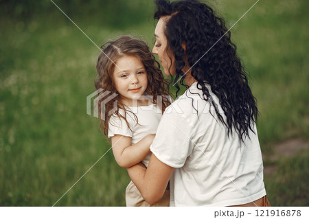 Family in a summer park. Mother in a white t-shirt. Cute little girl Family in a summer park. Mother in a white t-shirt. Cute little girl 121916878
