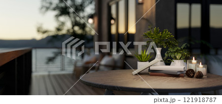 A close-up of a round wooden table with decors on a cozy home balcony with a nature view. A close-up of a round wooden table with decors on a cozy home balcony with a nature view. 121918787