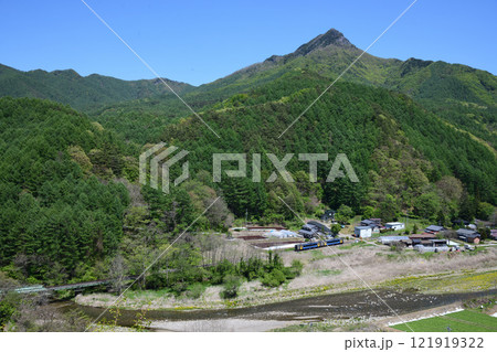 新緑の千曲川沿いの集落を通過する小海線のローカル列車 121919322