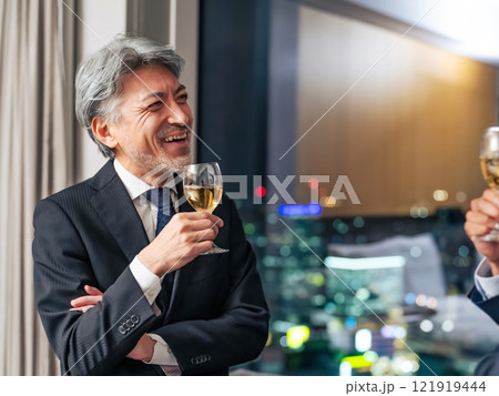 都市の夜景を背景に乾杯する多国籍ビジネスパーソン 都市の夜景を背景に乾杯する多国籍ビジネスパーソン 121919444