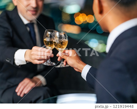 都市の夜景を背景に乾杯する多国籍ビジネスパーソン 121919448