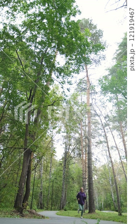 Portrait of young sportswoman jogging during outdoor training in park in the morning. Sport and healthy lifestyle concept Portrait of young sportswoman jogging during outdoor training in park in the morning. Sport and healthy lifestyle concept 121919467