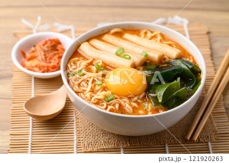 Spicy noodles soup with Tteokbokki, Wakame seaweed and fresh egg yok eating with kimchi cabbage 121920263