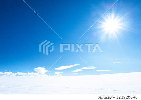 冬の北海道らしい雪原と青空と太陽のあるシンプルな風景 121920348