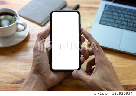 man hand using smartphone In the office Screen blank with clipping path ,Top view mockup image of male holding mobile phone with empty white screen 121920934