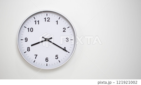 Minimalist White Clock with Silver Frame Striking 20.20/08.20 on White Background. Perfect for Time Management and Corporate Campaigns Minimalist White Clock with Silver Frame Striking 20.20/08.20 on White Background. Perfect for Time Management and Corporate Campaigns 121921002