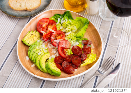 Lettuce and tomatoes served with chorizo and avocado Lettuce and tomatoes served with chorizo and avocado 121921874