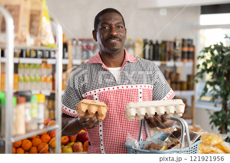 Adult man choosing eggs in grocery store 121921956