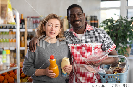 African husband and his wife are shopping in grocery store, looking for something in shop window African husband and his wife are shopping in grocery store, looking for something in shop window 121921990