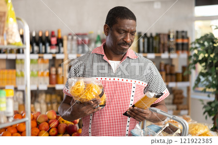 Adult man choosing pasta in store Adult man choosing pasta in store 121922385