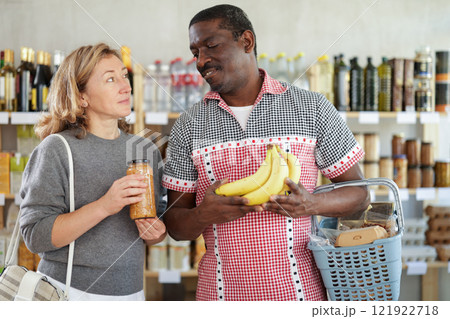 Couple man and woman choosing lentils and bananas 121922718