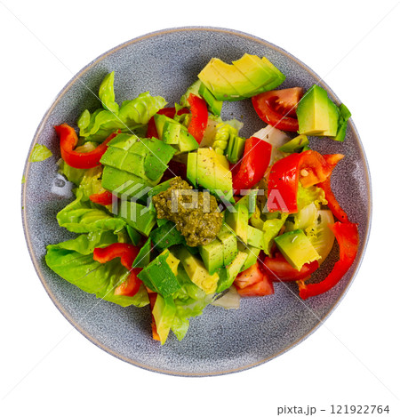Plate contains portion of salad from fresh vegetables and pesto sauce. 121922764