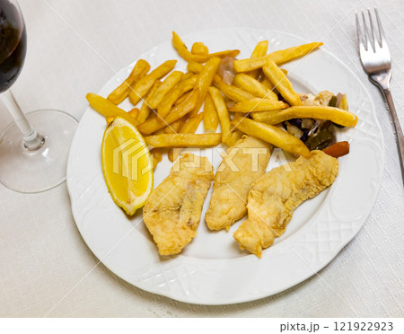 Battered fish with lemon and potatoes Battered fish with lemon and potatoes 121922923