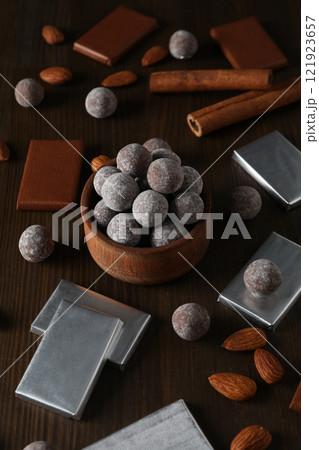 Chocolate balls in a wooden bowl with chocolate bars and almonds 121923657