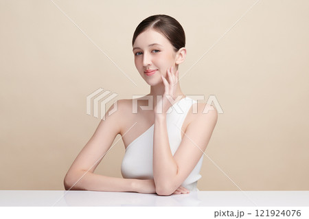 Beautiful young woman with clean fresh skin on beige background, Face care, Facial treatment, Cosmetology, beauty and spa, women portrait. 121924076