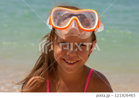 Portrait of caucasian child of 7-8 years in swimming mask looking at camera 121926465