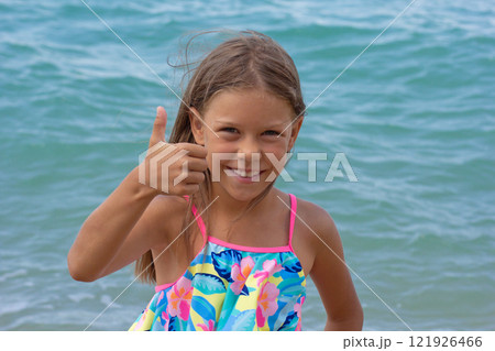 Beautiful happy caucasian child of 7-8 years with thumb up 121926466