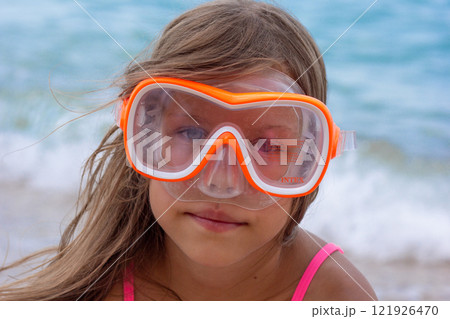 Portrait of caucasian child of 7-8 years in swimming mask looking at camera 121926470