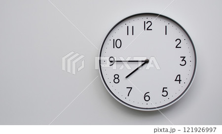 Minimalist Analog Wall Clock with White Face and Simple Black Hands Showing 19.45/07.45 - Ideal for Time Management and Modern Decor Concepts 121926997