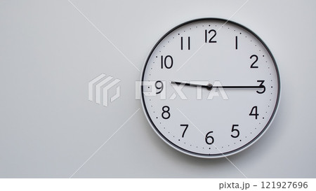 Minimalist Analog Wall Clock with White Face and Simple Black Hands Showing 21.15/09.15 - Ideal for Time Management and Modern Decor Concepts 121927696