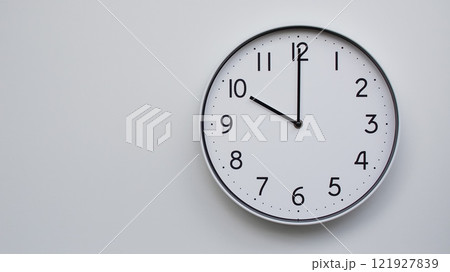 Minimalist Analog Wall Clock with White Face and Simple Black Hands Showing 22.00/10.00 - Ideal for Time Management and Modern Decor Concepts 121927839
