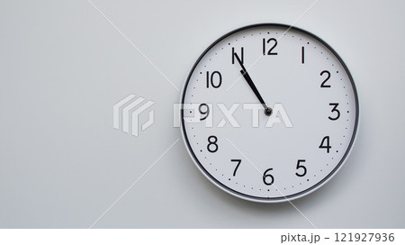 Minimalist Analog Wall Clock with White Face and Simple Black Hands Showing 10.55/22.55 - Ideal for Time Management and Modern Decor Concepts Minimalist Analog Wall Clock with White Face and Simple Black Hands Showing 10.55/22.55 - Ideal for Time Management and Modern Decor Concepts 121927936