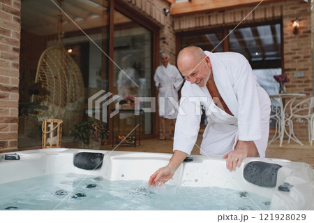 Romantic wellness getaway. Senior couple enjoying hot tub during Valentine's weekend. 121928029