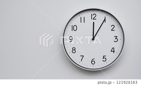 Minimalist Analog Wall Clock with White Face and Simple Black Hands Showing 12.05/00.05 - Ideal for Time Management and Modern Decor Concepts 121928163