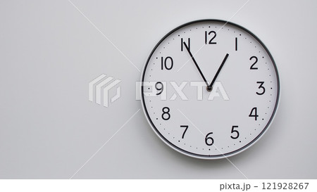 Minimalist Analog Wall Clock with White Face and Simple Black Hands Showing 12.55/00.55 - Ideal for Time Management and Modern Decor Concepts Minimalist Analog Wall Clock with White Face and Simple Black Hands Showing 12.55/00.55 - Ideal for Time Management and Modern Decor Concepts 121928267