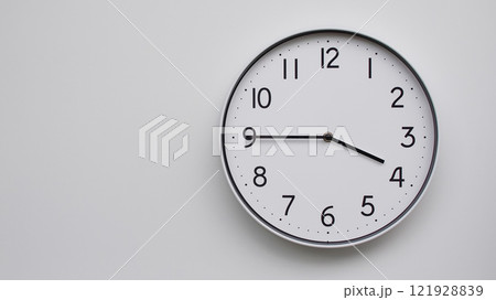 Minimalist Analog Wall Clock with White Face and Simple Black Hands Showing 15.45/03.45 - Ideal for Time Management and Modern Decor Concepts Minimalist Analog Wall Clock with White Face and Simple Black Hands Showing 15.45/03.45 - Ideal for Time Management and Modern Decor Concepts 121928839