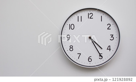 Minimalist Analog Wall Clock with White Face and Simple Black Hands Showing 16.25/04.25 - Ideal for Time Management and Modern Decor Concepts Minimalist Analog Wall Clock with White Face and Simple Black Hands Showing 16.25/04.25 - Ideal for Time Management and Modern Decor Concepts 121928892