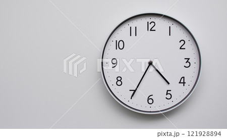 Minimalist Analog Wall Clock with White Face and Simple Black Hands Showing 16.35/04.35 - Ideal for Time Management and Modern Decor Concepts 121928894